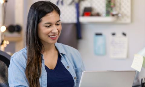Person in a home workroom signing up online for a continuing education course.